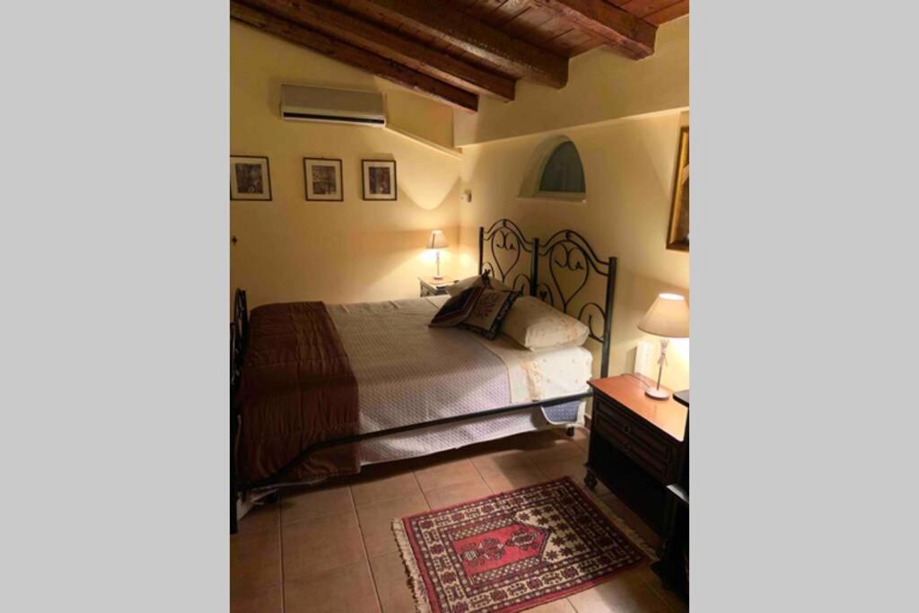 um quarto com uma cama, uma mesa e um tapete em Una piccola casa confortevole em Campobello di Licata