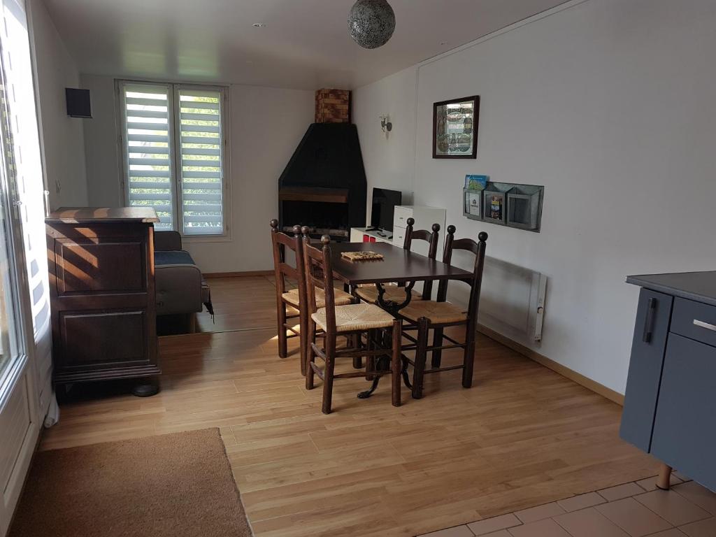 eine Küche und ein Esszimmer mit einem Tisch und Stühlen in der Unterkunft Appartement avec Terrasse in Saint-Aubin-sur-Mer