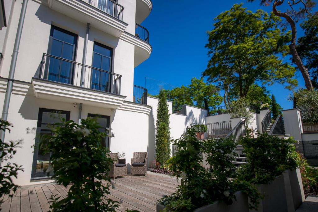 a white building with a wooden deck in front of it at Strandhotel Fontana in Timmendorfer Strand