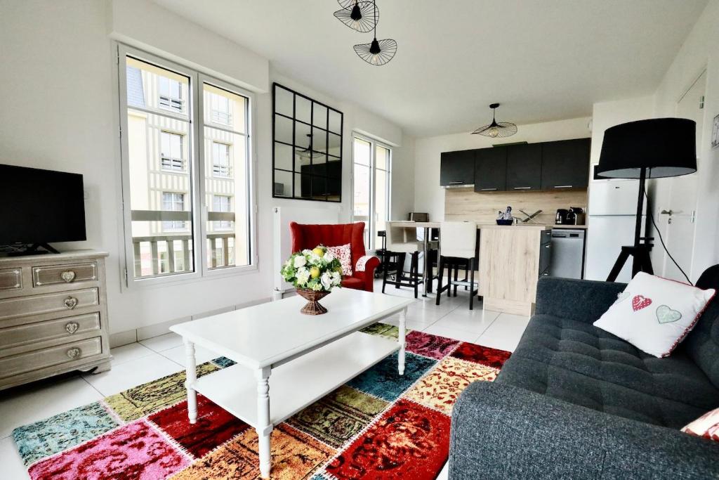 un salon avec un canapé et une table dans l'établissement Appartement des Arts, à Deauville