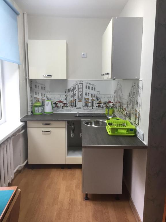 a kitchen with white cabinets and a green tray on a counter at Karja 5 Apartment in Narva-Jõesuu