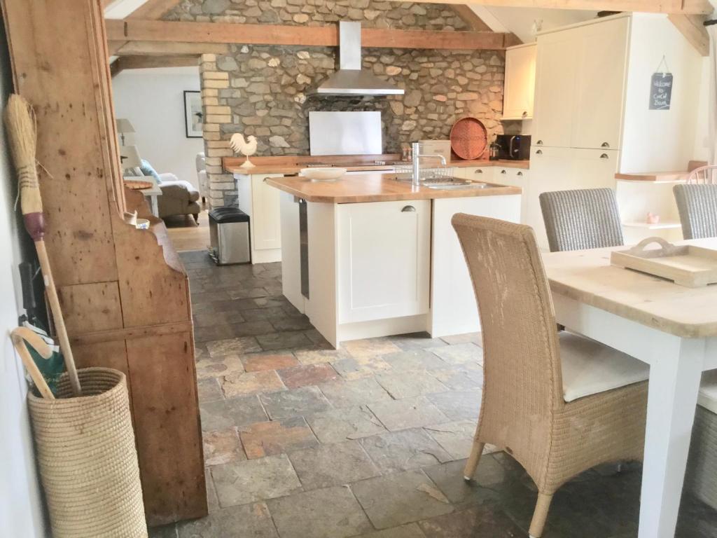a kitchen with a counter and a table and chairs at Cuckoo Barn at Penygaer farm near the Brecon Beacons in Llandovery