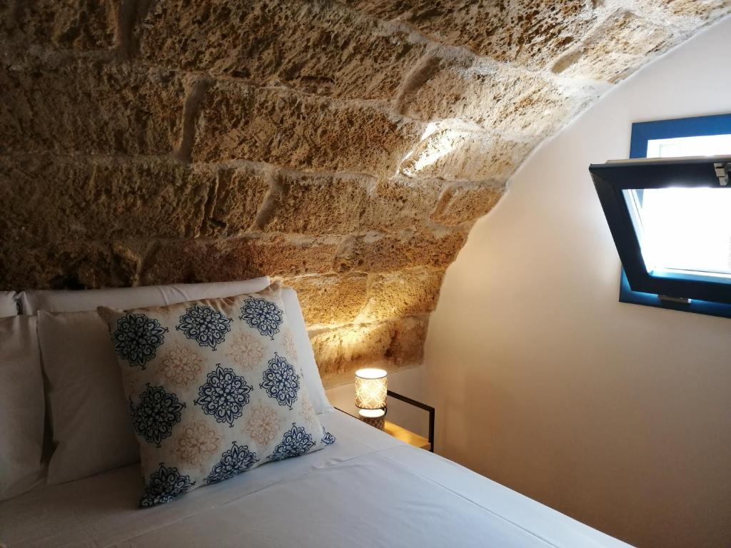 a bedroom with a bed with a stone wall at B&B Sea Salt in Terrasini