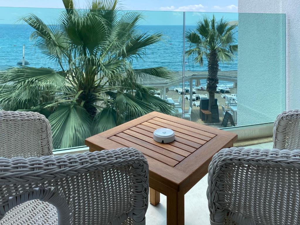 a wooden table and chairs with a view of the ocean at Zest Exclusive Hotel & Spa in Ortakent