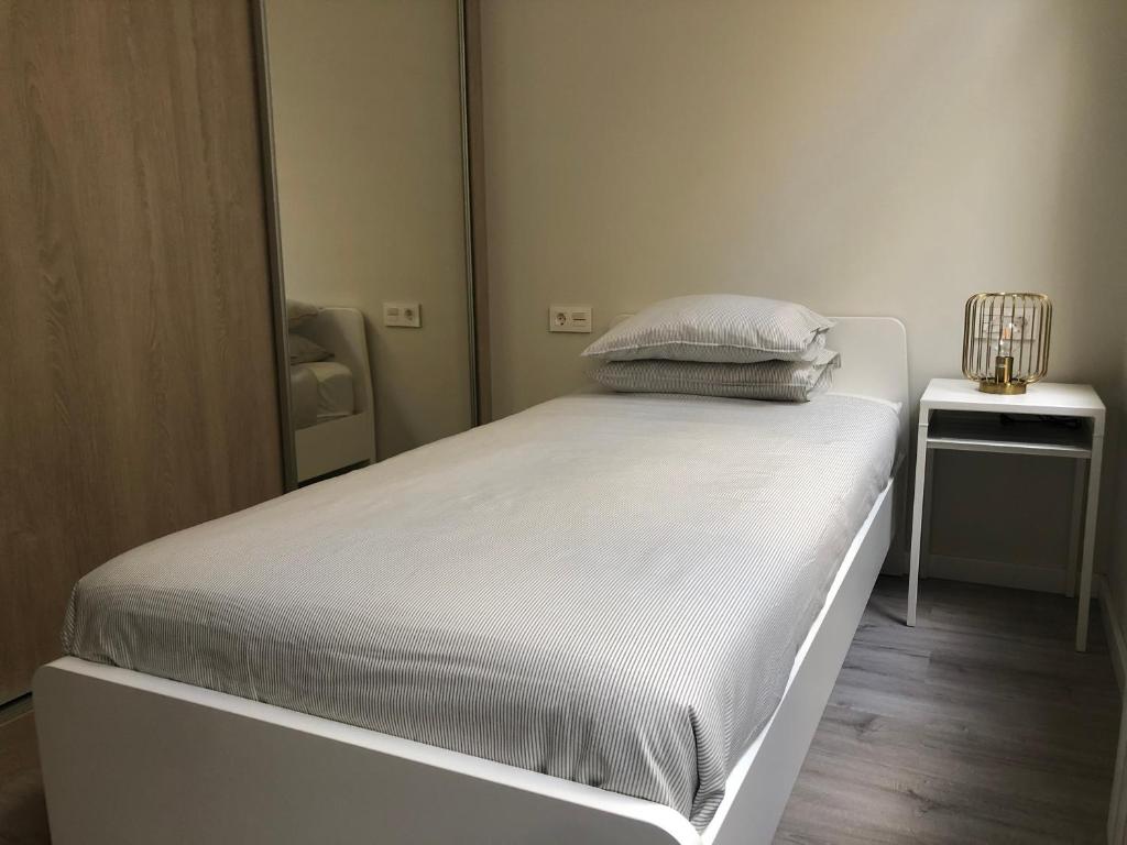A bed or beds in a room at Noray Apartamentos Viveiro