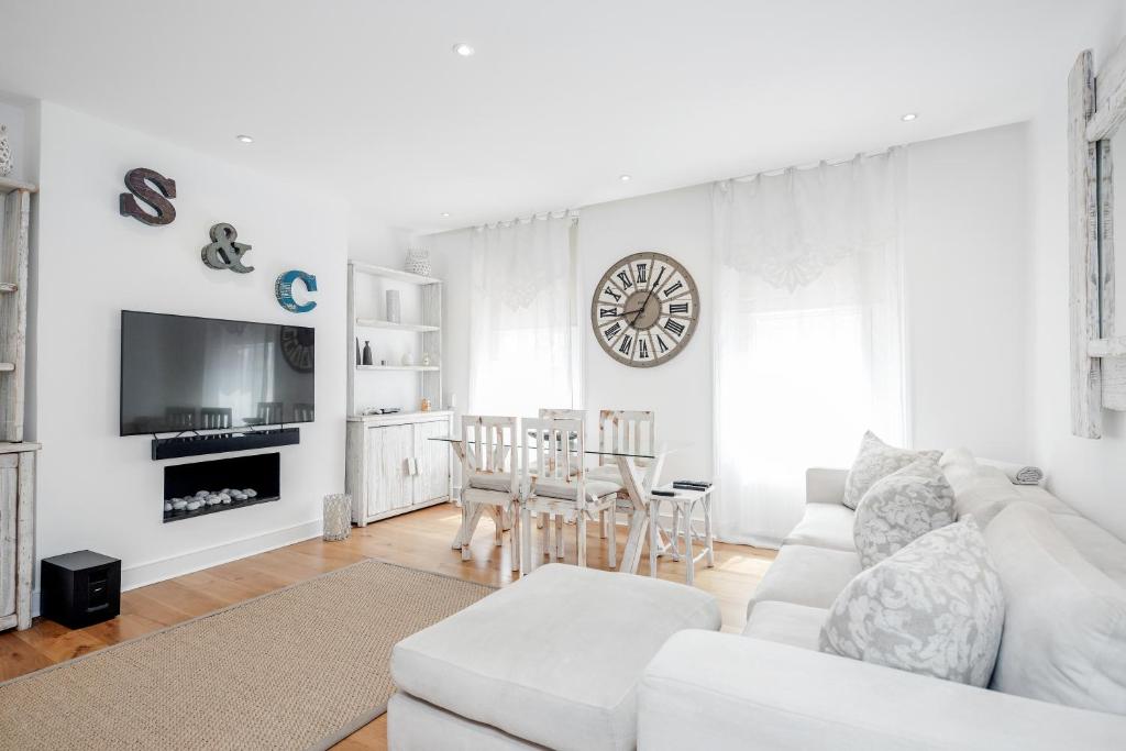 a white living room with a white couch and a table at The white home near Kensington high st in London