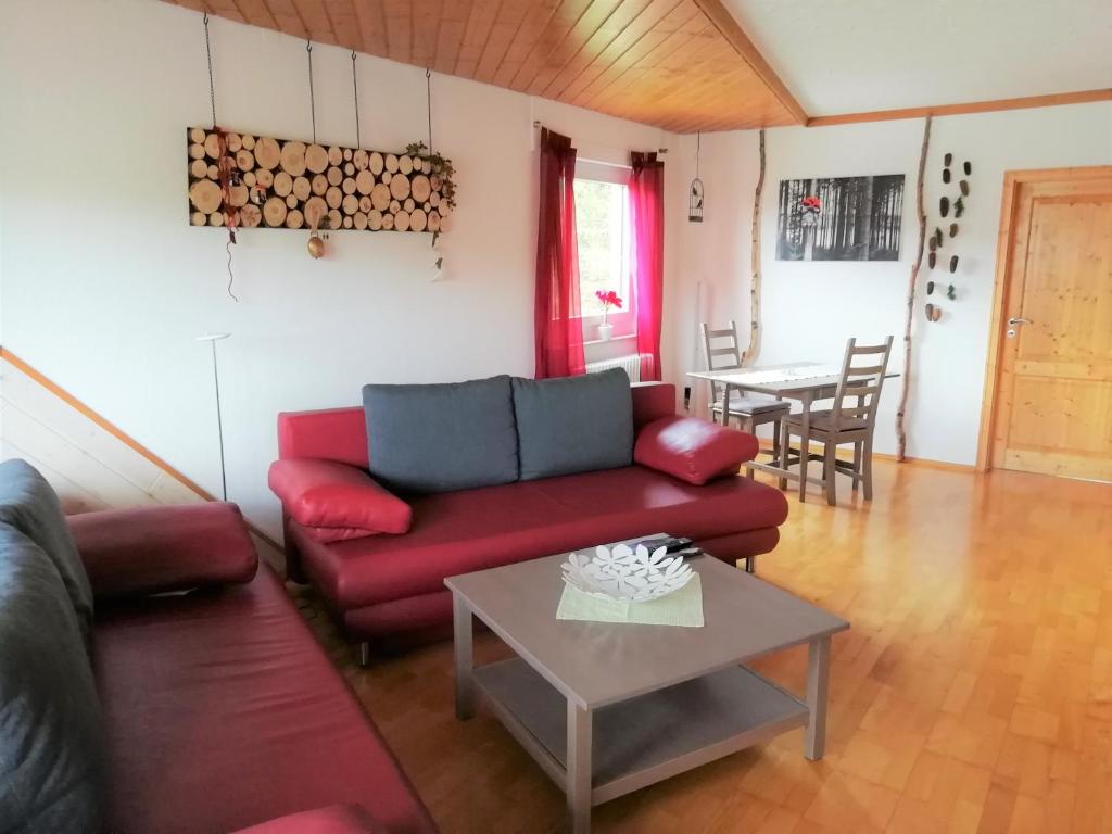 sala de estar con sofá rojo y mesa en Ferienwohnung Brasil en Schonach