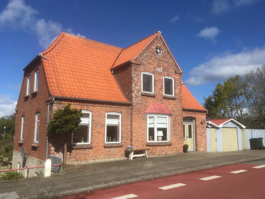 een stenen huis met een hond ervoor bij Herlebo in Tønder