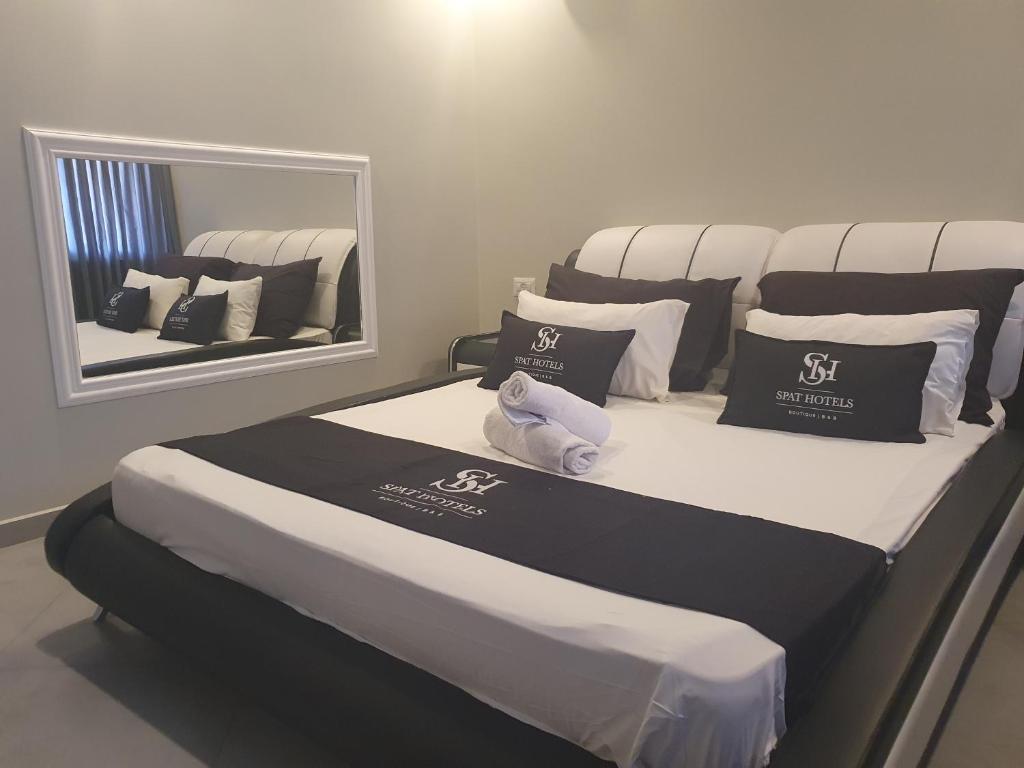 a large bed in a room with a mirror at Spat Business Holon in H̱olon