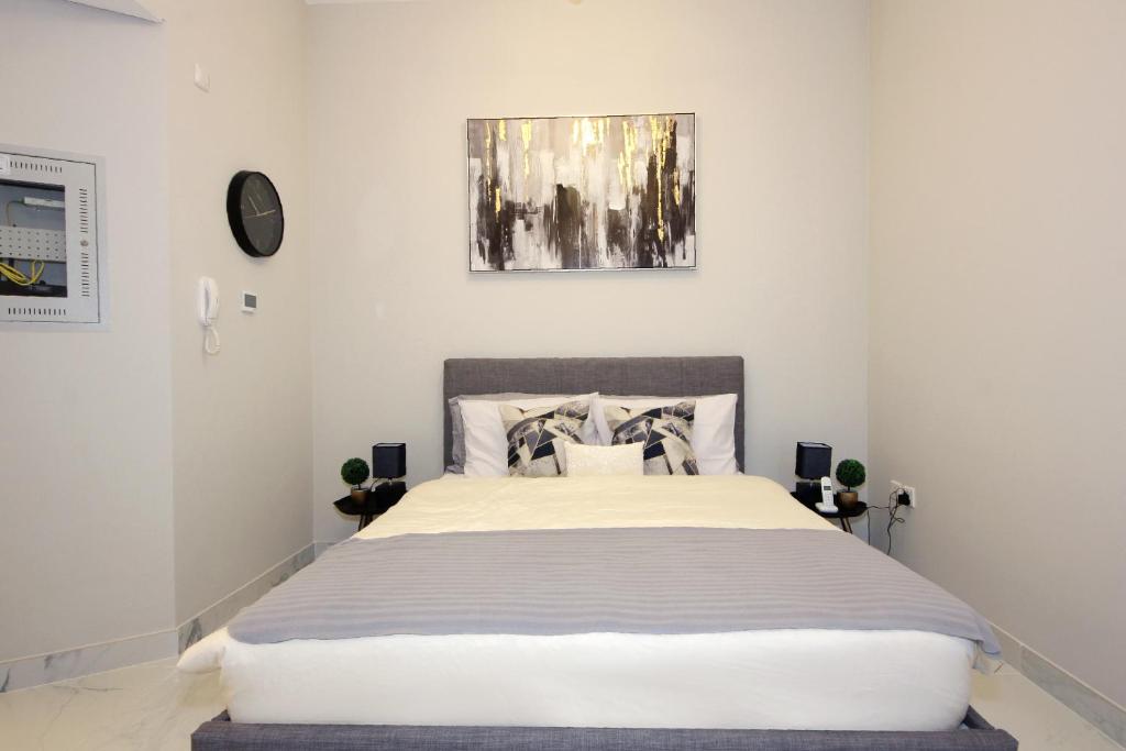 a white bedroom with a large bed in it at SHH - Furnished Studio in MAG 5, Dubai South Near to Expo 2020 in Dubai