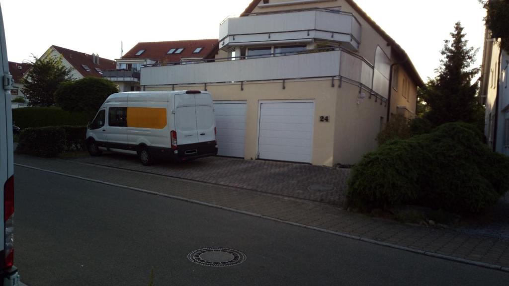 una furgoneta blanca estacionada frente a un garaje en Komfort Apartment 2 EG bei Jürgen Kunzi, en Filderstadt