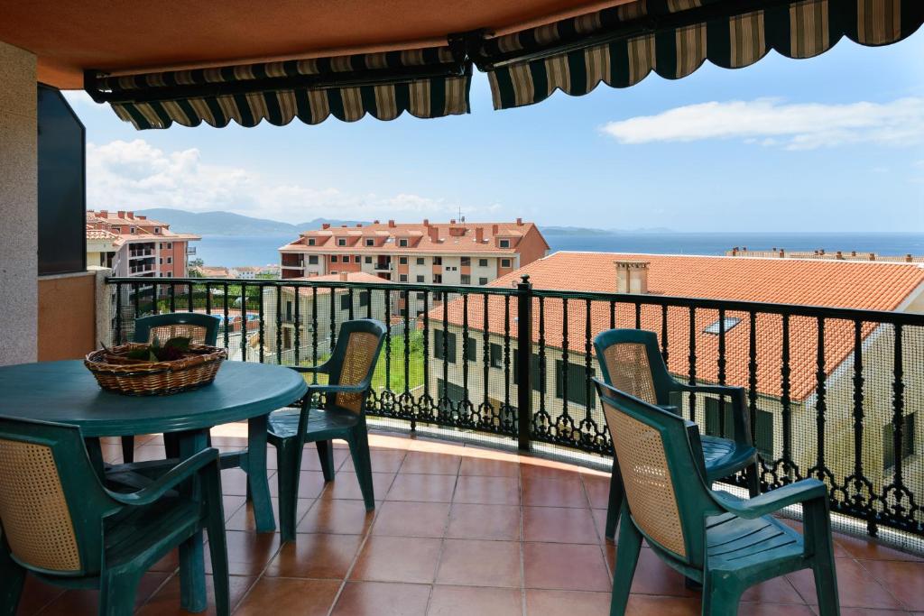 einen Balkon mit einem Tisch und Stühlen sowie Meerblick in der Unterkunft APARTAMENTO VISTAS MAR in Sanxenxo