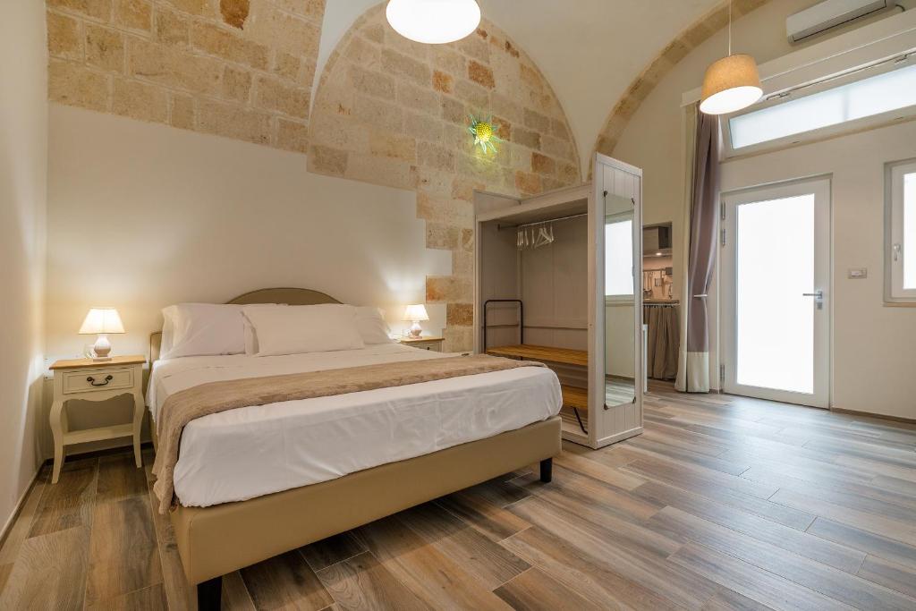 a bedroom with a large bed and a brick wall at Dimora Cavour in Polignano a Mare