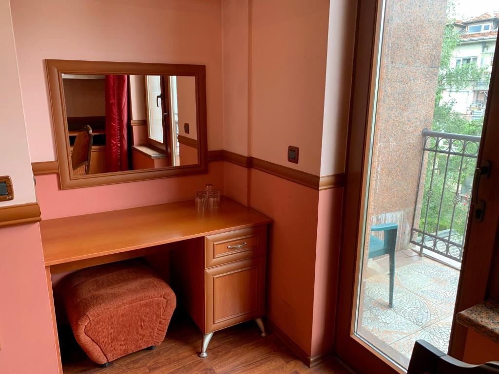 a bathroom with a vanity with a mirror and a window at California Hotel in Sofia
