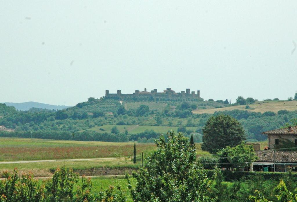 un castillo en una colina en un campo verde en S.M. L'ARCO, en Monteriggioni