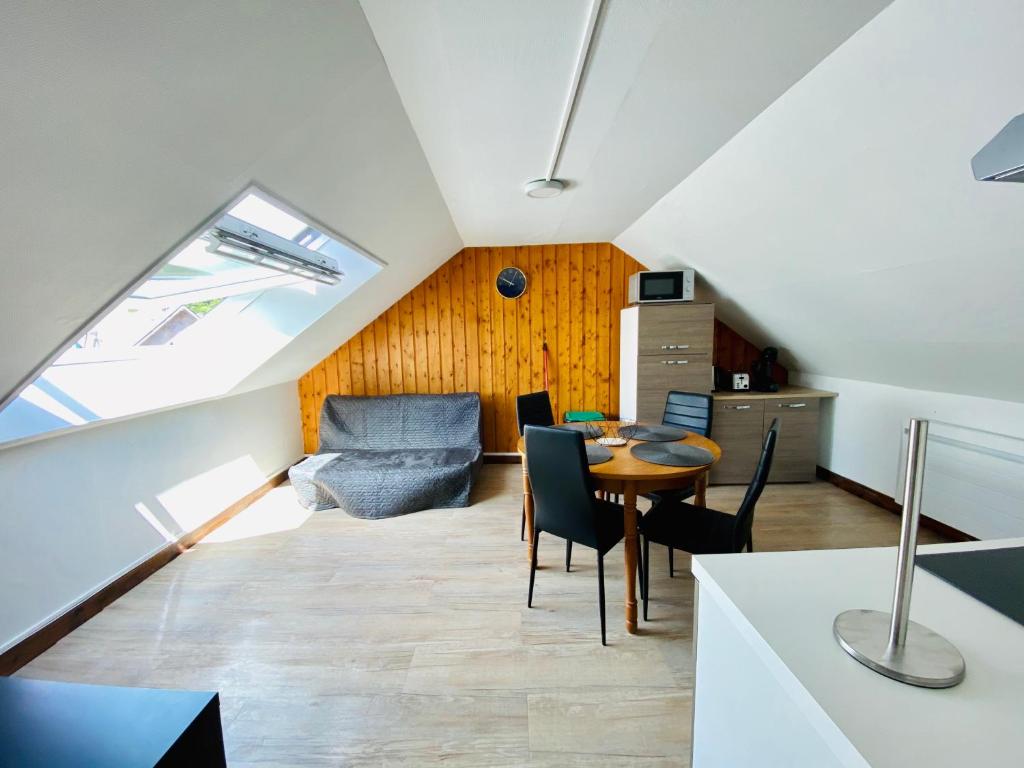 a attic living room with a table and chairs at résidence les pâquerettes N 4 in Le Mont-Dore