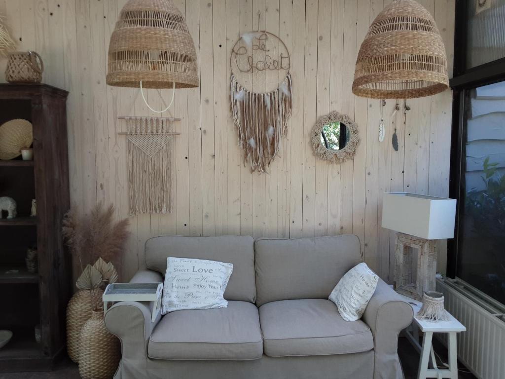 sala de estar con sofá y 2 cestas colgantes en LE CHALET, en Spa