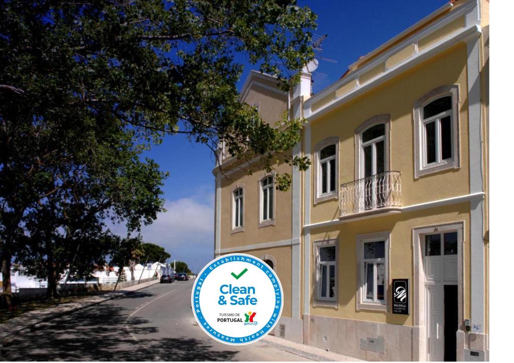 a sign in front of a yellow building at Marina Charming House in Figueira da Foz