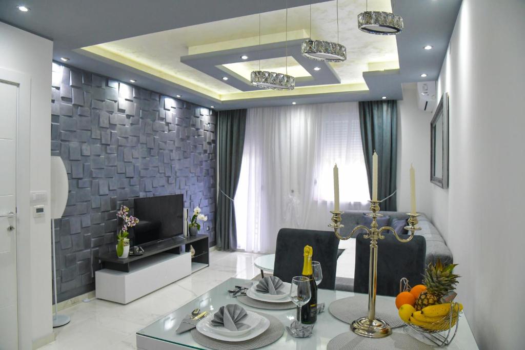 a living room with a dining table and a television at Apartman Nina in Sremska Mitrovica