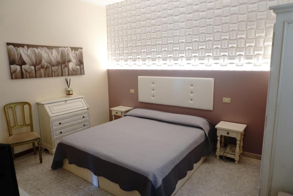 a small bedroom with a bed and a dresser and a bed sidx sidx sidx at Hotel Atlantico in Castiglioncello