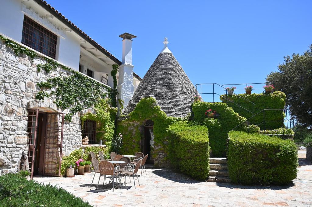 una casa con tavolo e sedie nel cortile di Masseria Iazzo Scagno a Martina Franca