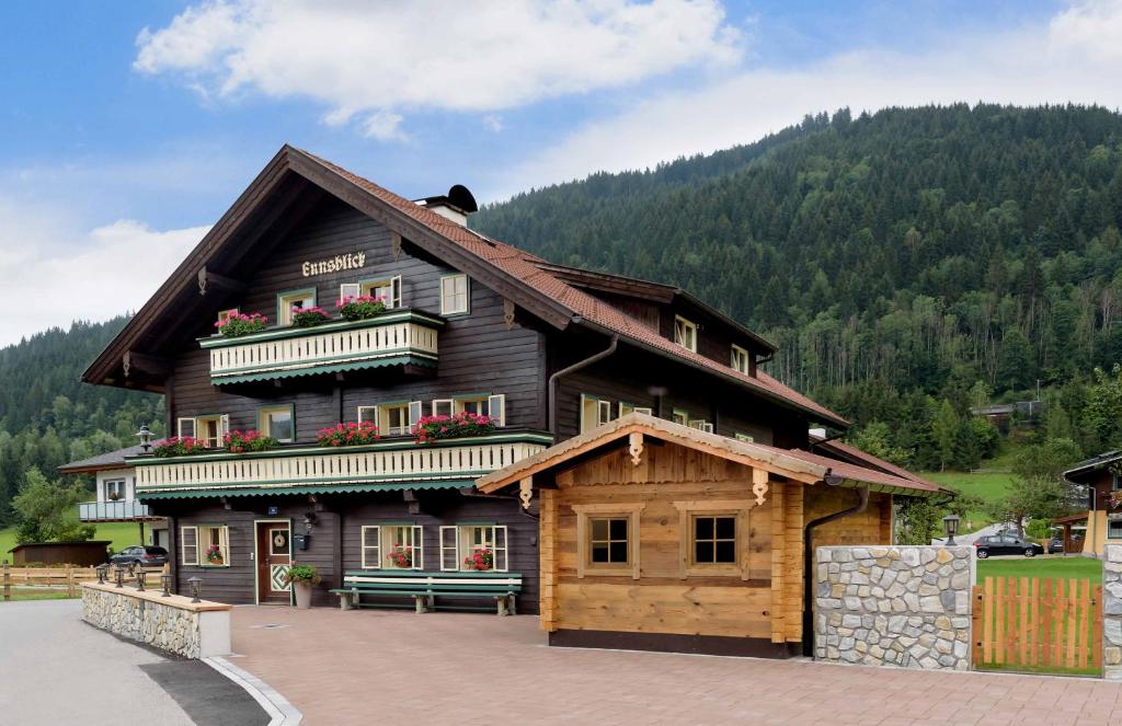 a large wooden building with flowers on the balcony at Haus Ennsblick in Flachau