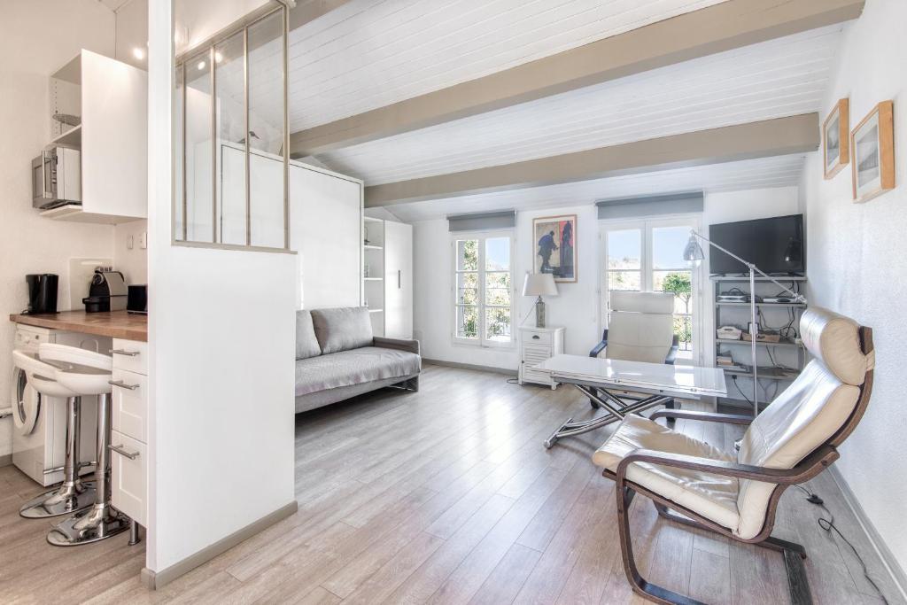 una sala de estar con un escritorio y un sofá en Studio Vue Mer, en Saint-Martin-de-Ré