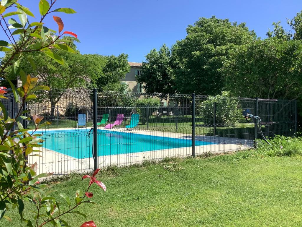 a fence around a swimming pool in a yard at Le Papillon De Soie in Pierrelatte