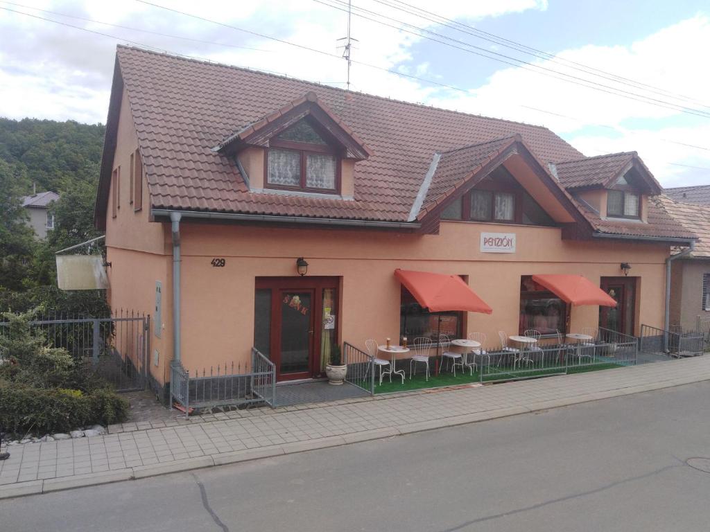 a house with tables and chairs in front of it at Ubytovanie Penzión Iveta in Poltár