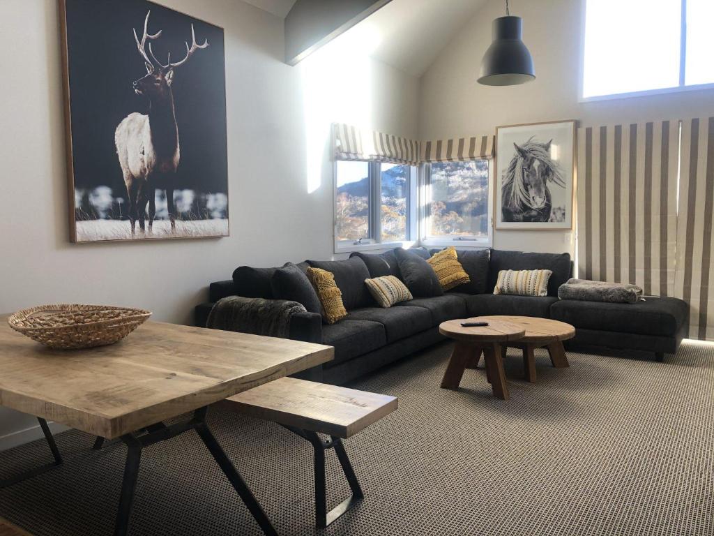 a living room with a couch and a table at Lodge Chalet 16 - The Stables Perisher in Perisher Valley