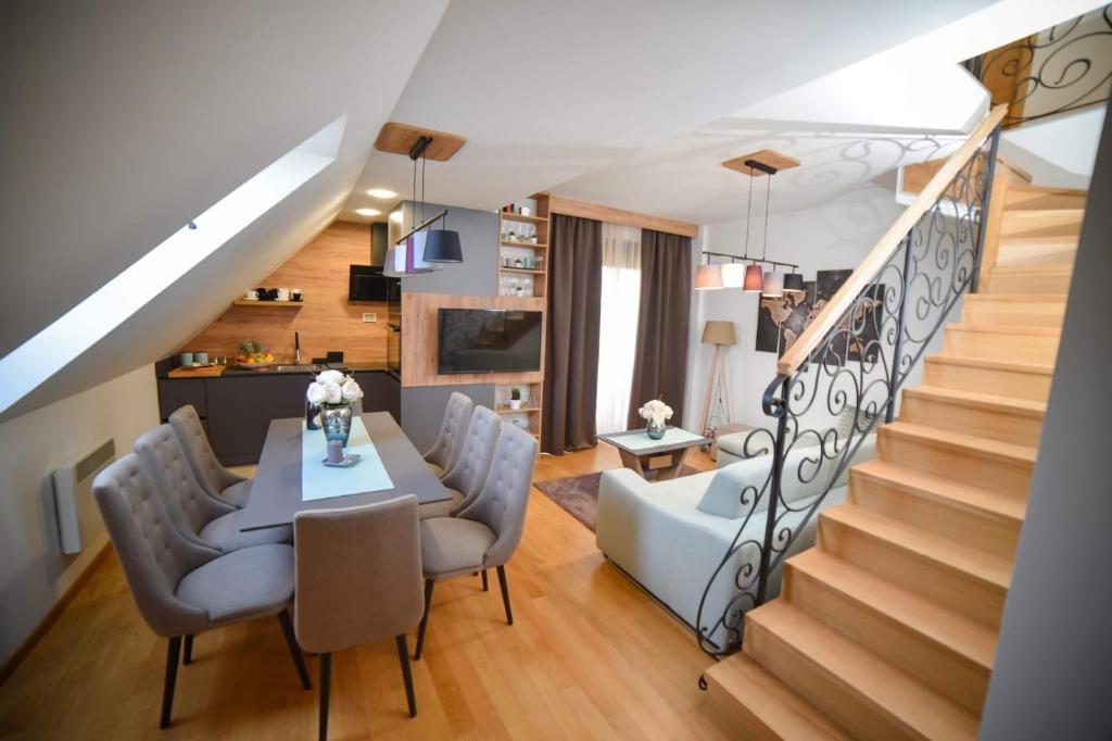 een woonkamer met een tafel en stoelen en een trap bij Mountain Residence Zlatibor - Apartman Sara 1 in Zlatibor