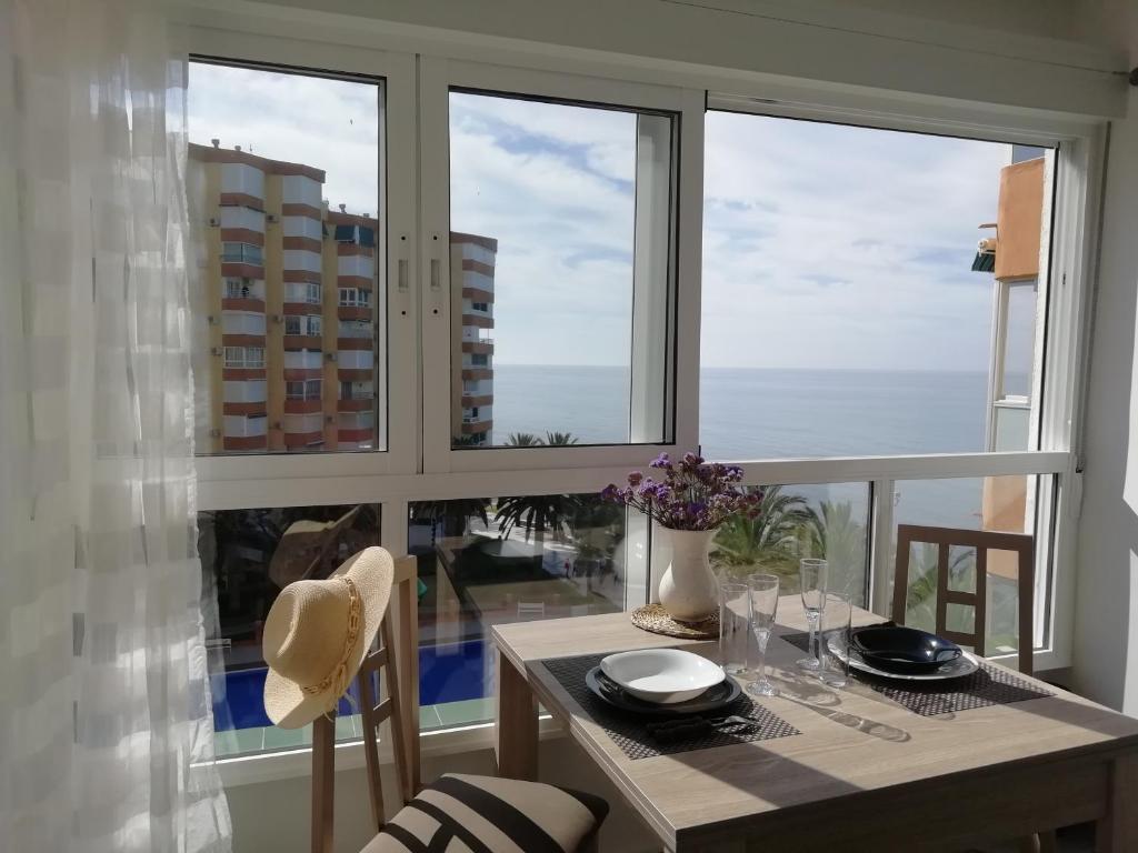 comedor con mesa y 2 ventanas en Pitaya en Algarrobo-Costa