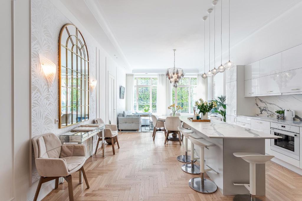 a white kitchen with a table and chairs in it at Jogailos Residence peaceful Old Town luxury 3 bdr, 2 bthr, FREE GARAGE, top-speed WIFI in Vilnius