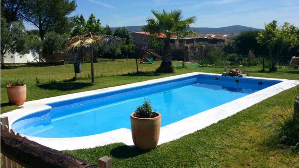 una piscina con dos macetas en un patio en 5 bedrooms villa with private pool jacuzzi and furnished terrace at Mirandilla, en Mirandilla