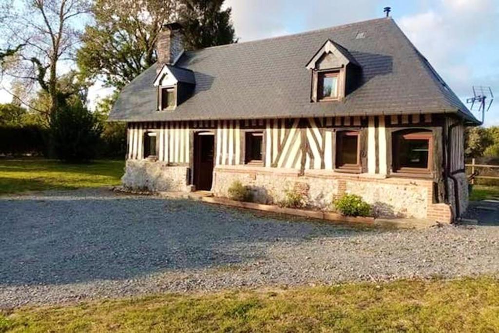 a house with a gravel driveway in front of it at Maison de 2 chambres avec wifi a Le Theil en Auge in Le Theil-en-Auge