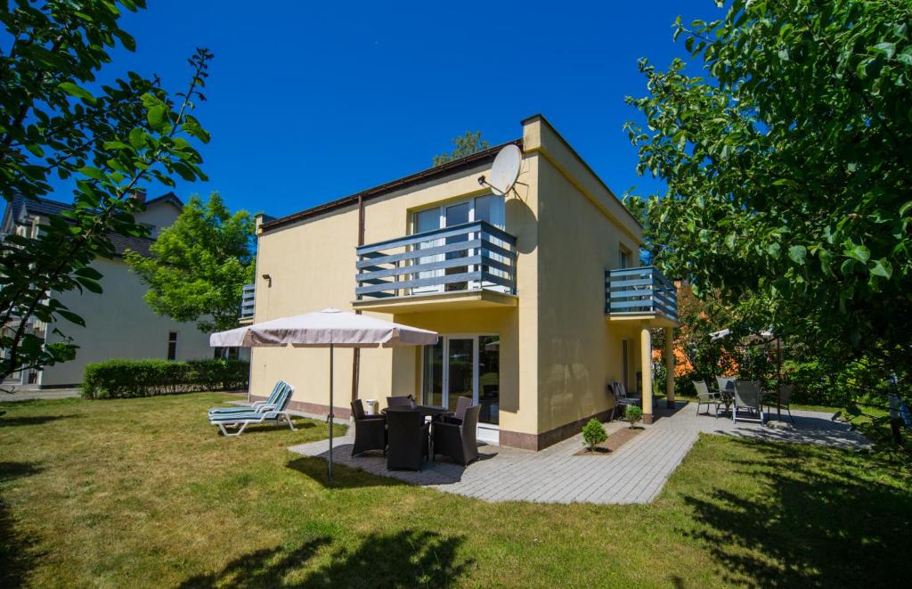 budynek z parasolem i krzesłami na dziedzińcu w obiekcie Villa LILIA w mieście Międzywodzie
