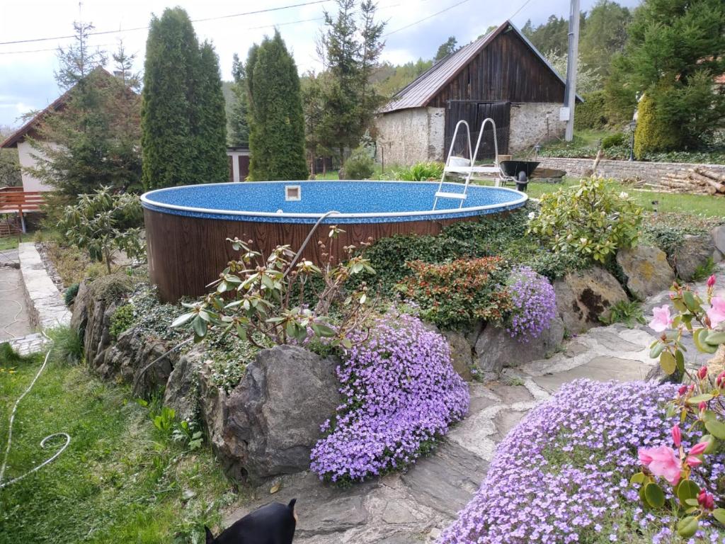 a bath tub in a garden with purple flowers at Ubytování na Šumavě in Sušice