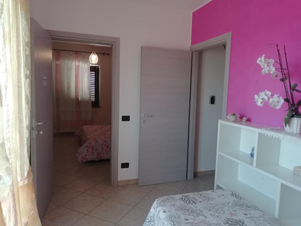 Zimmer mit lila Wänden und einem Zimmer mit einem Bett in der Unterkunft Aria Di mare in San Nicola Arcella