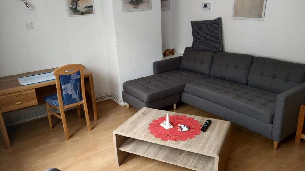 ein Wohnzimmer mit einem Sofa und einem Tisch mit Kerzen in der Unterkunft Apartment Zur Kogge in Wilhelmshaven