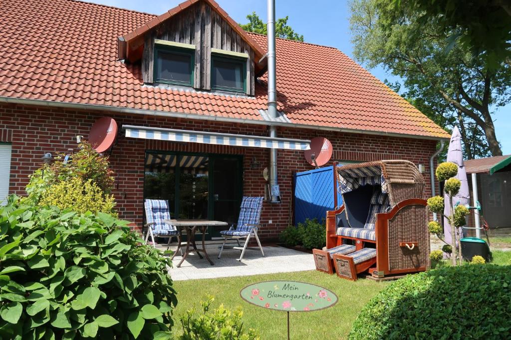 ボルテンハーゲンにあるFerienhaus Blomengoornの庭のテーブルと椅子付きの家
