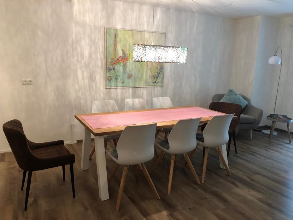 a dining room with a wooden table and chairs at Ferienwohnung CaLuMa in Wangen im Allgäu