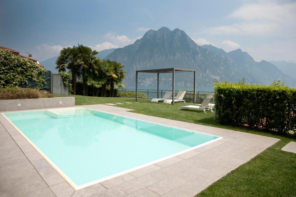 a blue swimming pool with a view of the mountains at Ai Ronchi B&B in Riva di Solto