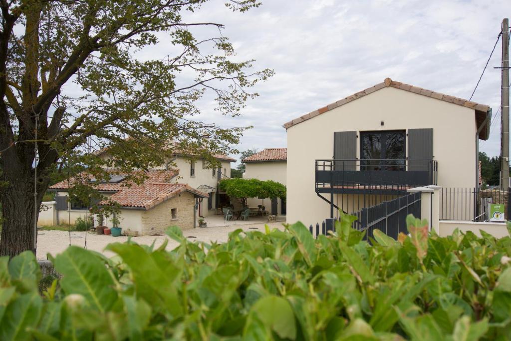 Casa con balcón frente a un patio en Gîtes Du Mas de Surlan, en Chantemerle-les-Blés