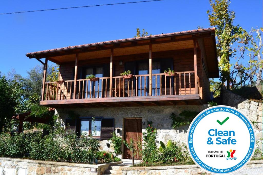 uma casa com varanda e um sinal em frente em Casa de Sao Joao em Gandarela