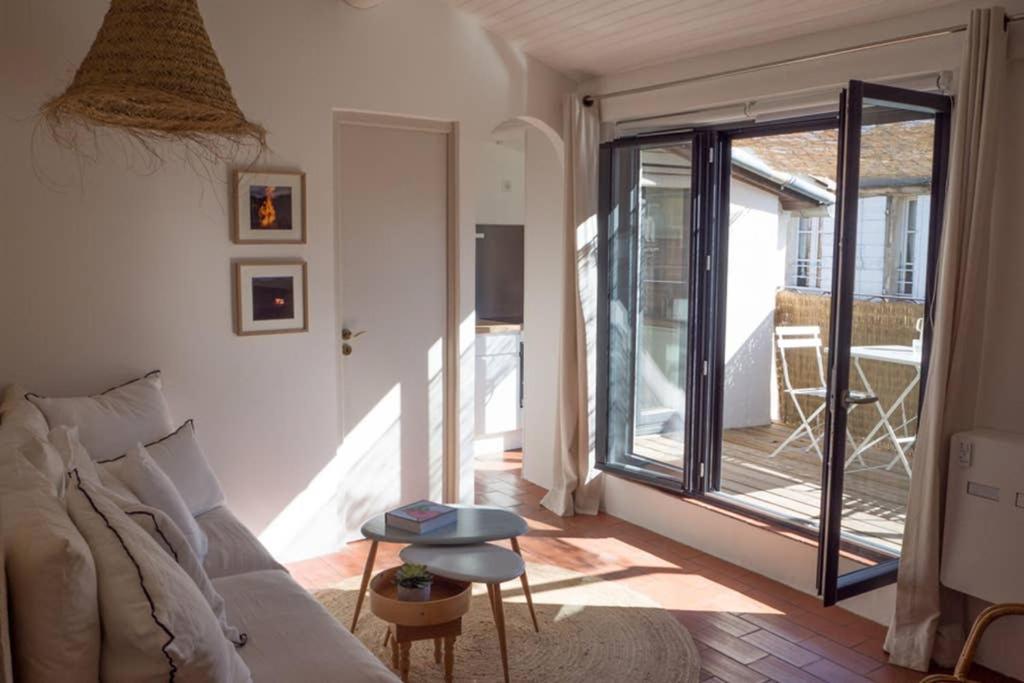 sala de estar con sofá y puerta de cristal en Arles sous les toits - Terrasse proche des arènes en Arlés