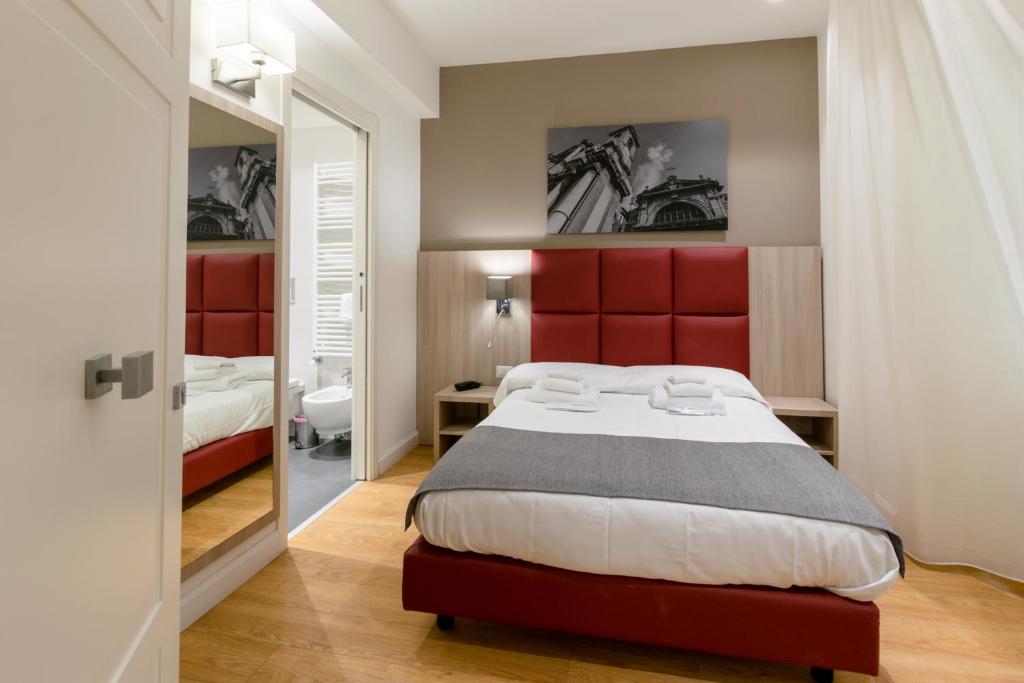 パレルモにあるBelmonte102 Esclusive Suitesのベッドルーム1室(大型ベッド1台、赤いヘッドボード付)