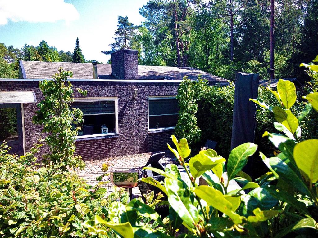 a brick house in the middle of a garden at De Drie Beuken in 't Harde