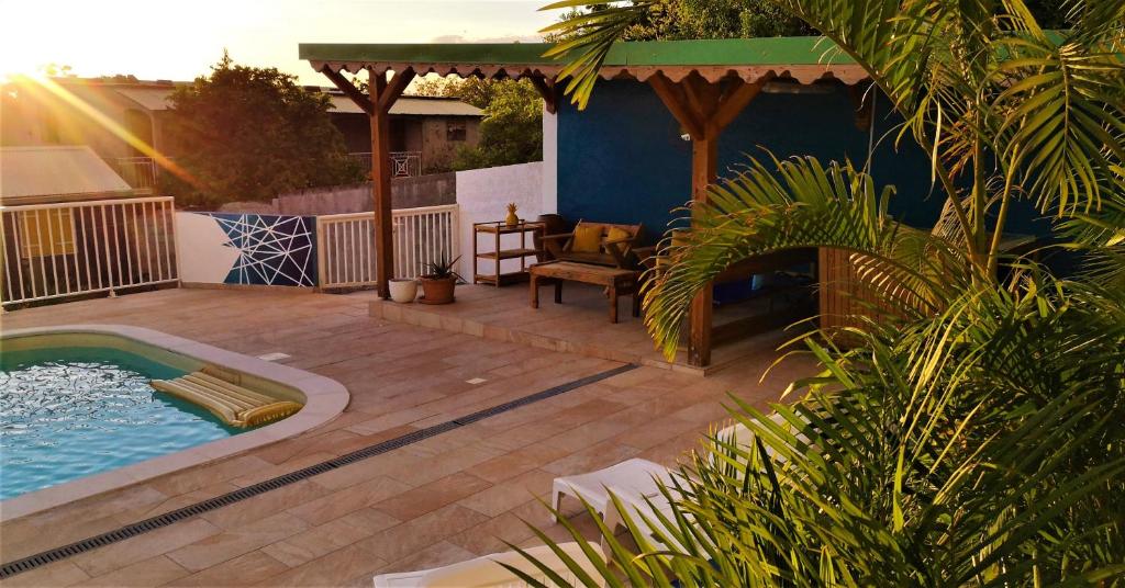 a backyard with a swimming pool and a wooden deck at Les Merveilleux Flots de la Mer in Deshaies