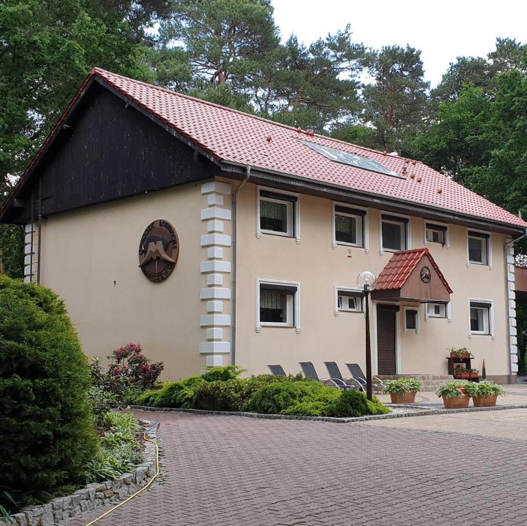 un gran edificio blanco con techo rojo en Villa Maniszewo, en Serbów