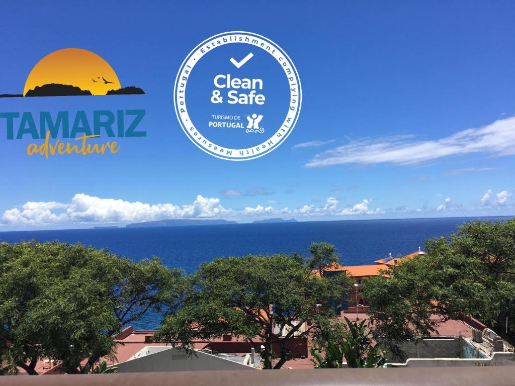 een bord dat schoon en veilig leest met de oceaan op de achtergrond bij Tamariz Adventure - Sea View and Free Parking in Caniço